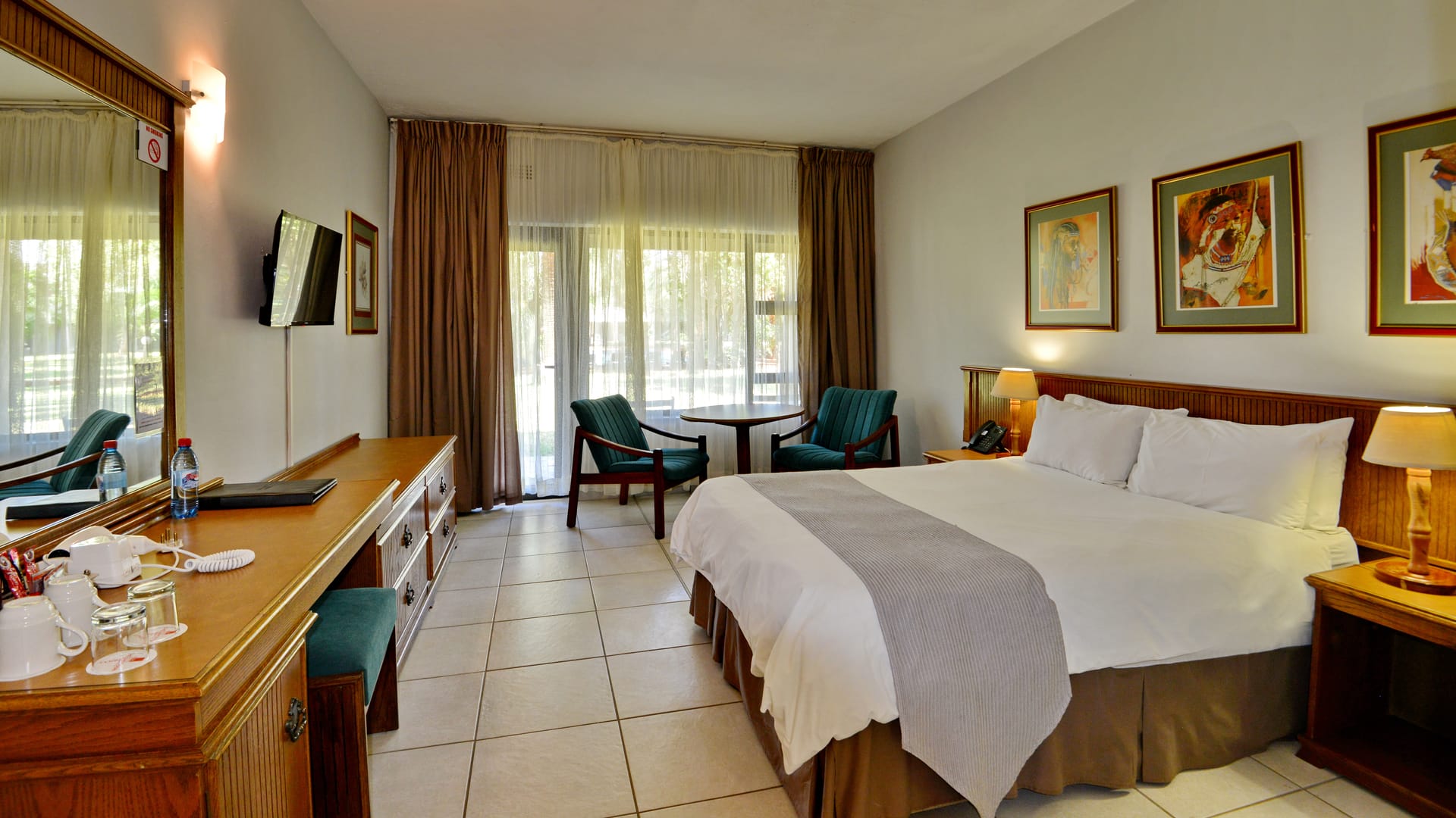 A double room with white linen and the garden through the sliding door